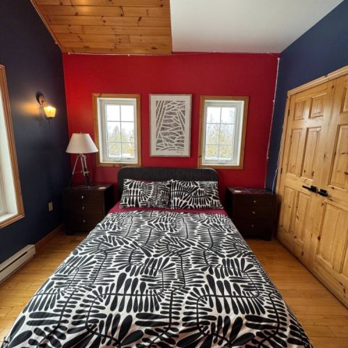 Wake up to forest views in this sunny, cozy bedroom with high ceilings and a modern flair—ideal for couples or solo escapes.