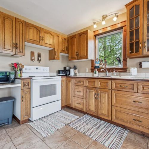 The kitchen boasts solid oak cabinetry, a full suite of appliances, and ample space for preparing meals together.