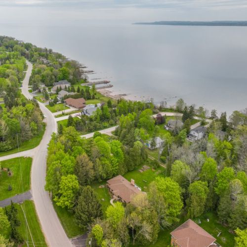 Sweeping aerial view of Georgian Bay’s sparkling shoreline, dotted with peaceful cottages and forested charm—your escape begins here.