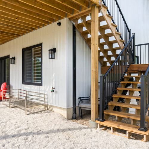 Exterior stairs provide easy access between the upper deck and lower patio.