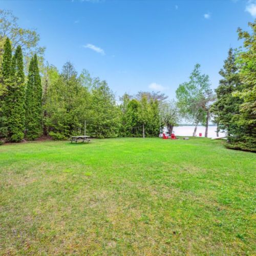 Let the kids play or host a lawn game on this wide-open yard nestled in a private woodland setting just steps from the water.