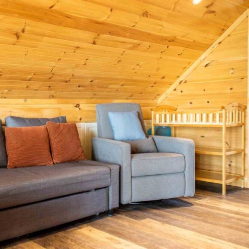 Family-friendly loft area with crib, seating, and extra sleeping space.