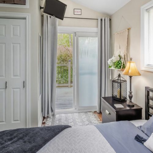 Wake up to forest views and direct deck access from this bright bedroom. Ideal for nature lovers and peaceful cottage getaways.