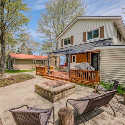 The backyard features a fire pit area, perfect for evening gatherings under the stars.