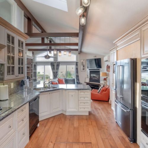 An open-concept kitchen flows into the living space with vaulted ceilings and natural light. Designed for gathering and relaxed vacation living.