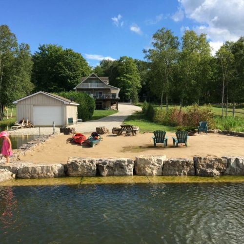 Jack's Retreat offers a private sandy beach on the shores of Little Lake, the ideal setting for sun-soaked memories and lakeside bonfires.