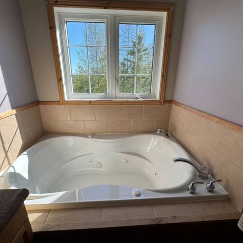 Enjoy spa-like luxury in the deep soaker tub with serene treetop views—perfect for unwinding after outdoor adventures