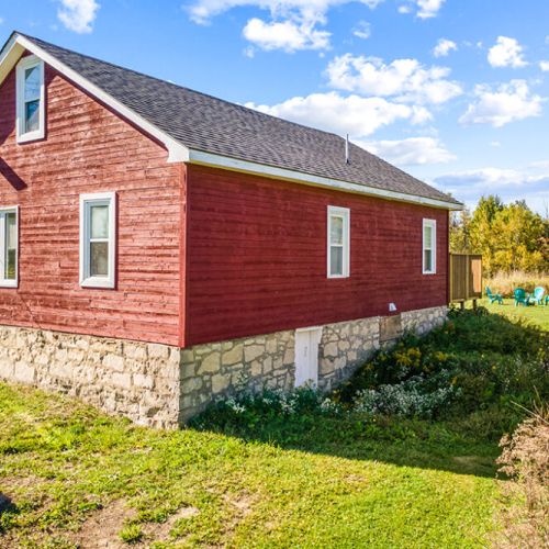 Classic farmhouse character shines through in the historic red exterior and stone foundation of Smith Homestead.