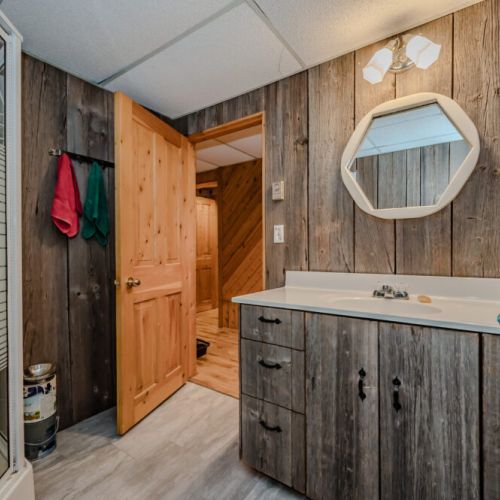 A charming rustic bathroom with reclaimed wood cabinetry and modern fixtures. Its unique design offers a blend of functionality and character for a delightful experience.