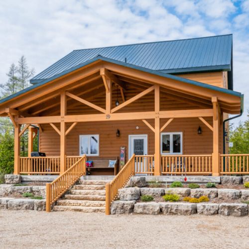 A massive Southern-style porch greets you as you arrive, wrapping around the side of the cottage and overlooking the yard.