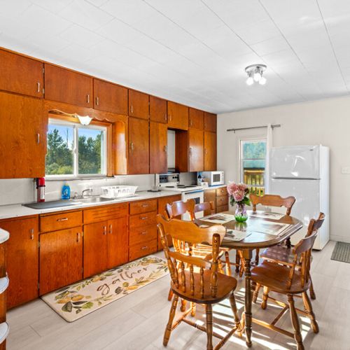 The spacious farmhouse kitchen and dining area offers plenty of room to prepare meals and gather together.