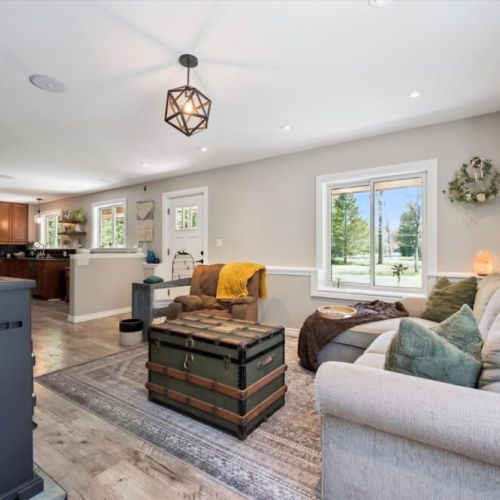 Relaxing seating area with large windows bringing in natural light and views of the surrounding countryside.