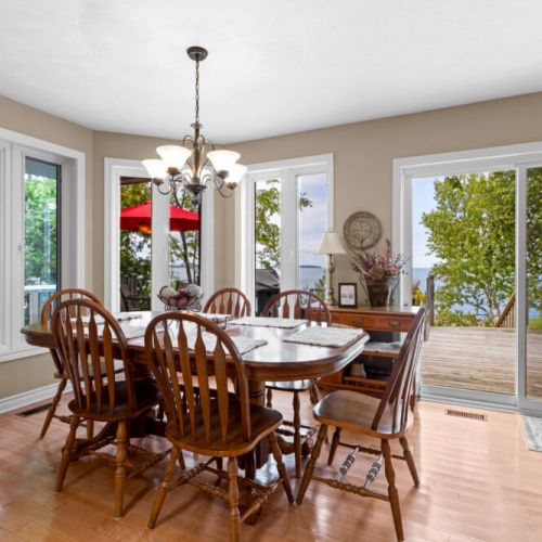 Enjoy meals with a view in the bright dining area, surrounded by windows overlooking the deck and waterfront.