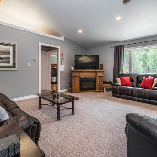 Enjoy the view of the West lawn from the spacious living room, tastefully decorated, and with comfortable furniture for lounging around.