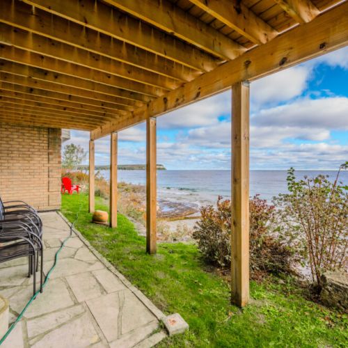 Covered patio with ocean view, a serene spot for taking in the beauty of the shoreline.