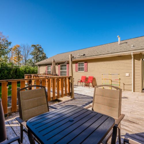 The spacious deck is perfect for relaxing in the evening, featuring warm lighting and a BBQ area, ideal for enjoying meals outdoors.