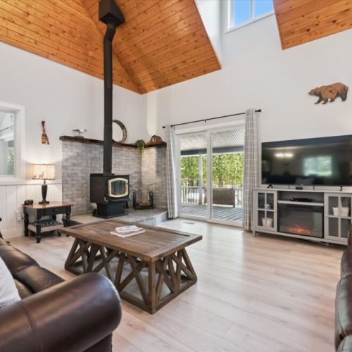 Bright and inviting living room with soaring wood ceilings, cozy seating, and a warm atmosphere.