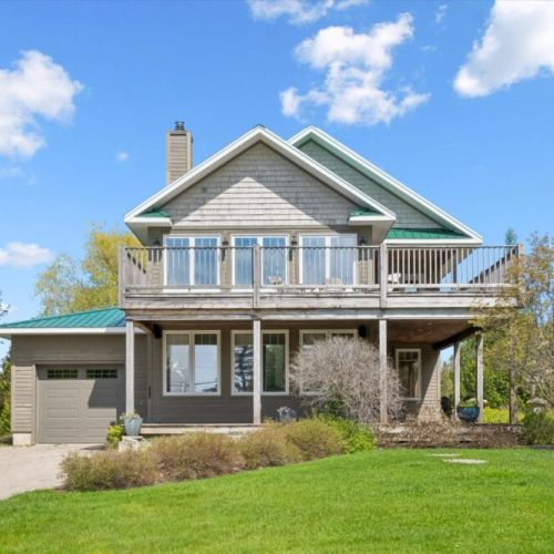 Beautiful exterior view of the cottage with expansive upper-level deck space.