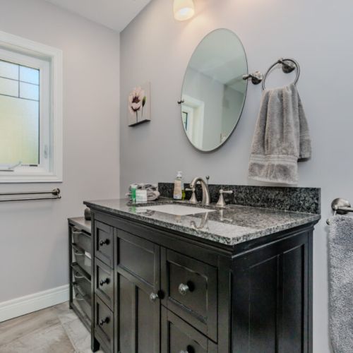 Bright and modern bathroom featuring a granite countertop and stylish fixtures—perfect for a relaxing stay at this well-appointed vacation rental, ideal for your next getaway or extended travel retreat.