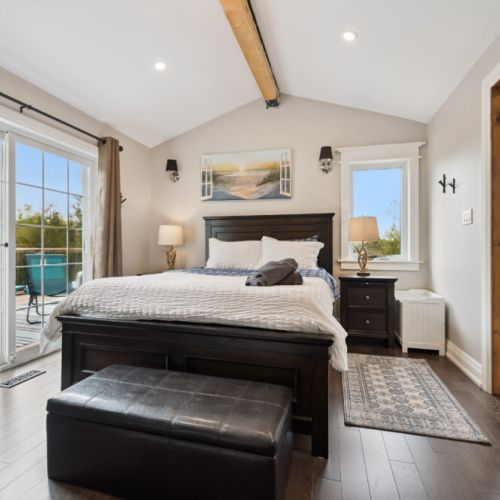 Bedroom 1: The master bedroom features a comfortable queen-sized bed, a private bathroom with a tub, and direct access to a quiet, secluded deck with a swing for a peaceful retreat. 100% cotton sheets are provided to ensure a comfortable stay.