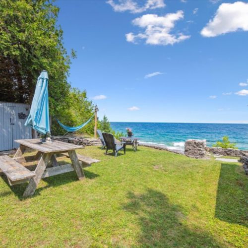 Picnic table, hammock, and chairs for sunny days by the water.