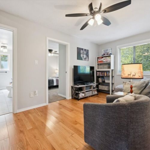 Cozy upper-level lounge area with comfortable seating, TV, and extra space for guests to relax and unwind.