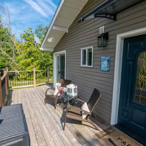Charming front porch sitting area, a welcoming space to unwind with a book or chat over a glass of wine.