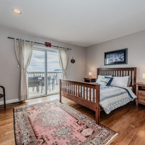 Wake up to breathtaking water views from the ground-level primary suite, conveniently located on the main floor. Step directly onto the deck to soak in the beauty of Georgian Bay and enjoy a seamless connection to the tranquil waterfront setting
