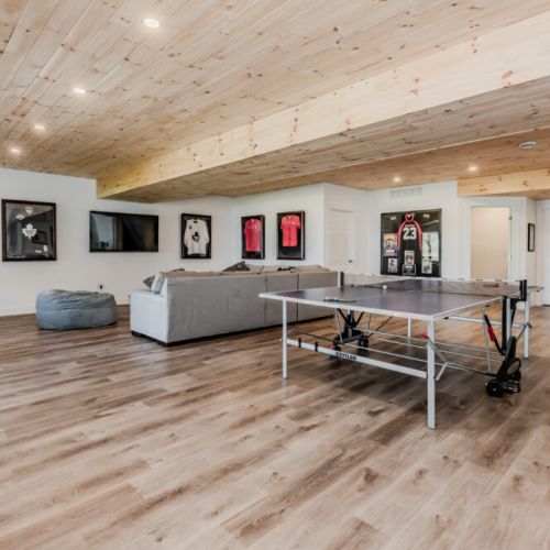 The recreation room has easy access to the outdoor spaces. The room's design encourages both relaxation and activity, with a table tennis table for some friendly competition.