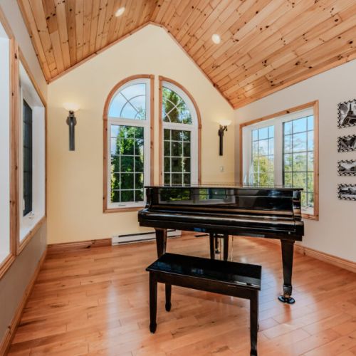 Relax in this sun-drenched music nook with a grand piano and panoramic views—ideal for morning coffee, reading, or letting creativity flow during your vacation getaway.