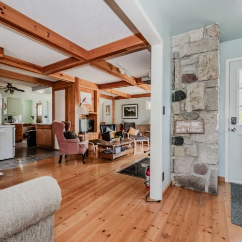 Step inside to discover a charming cottage atmosphere, highlighted by numerous wooden details and a warm fireplace that ensures a cozy environment.