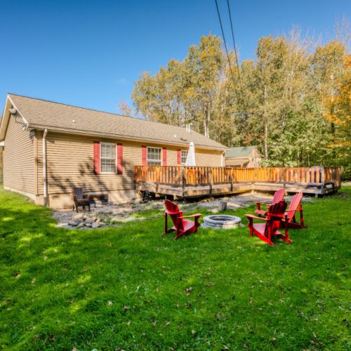 The back deck offers a perfect spot for morning coffee or evening relaxation, with plenty of seating and views of the surrounding nature.