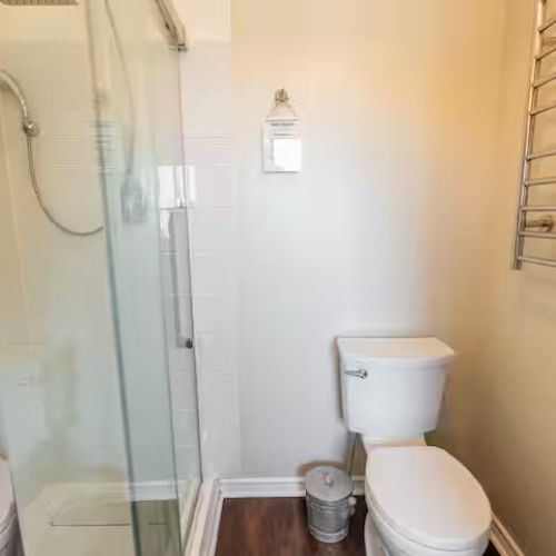 The main 3-piece bathroom featuring a glass shower, located close to the second bedroom and living area.
