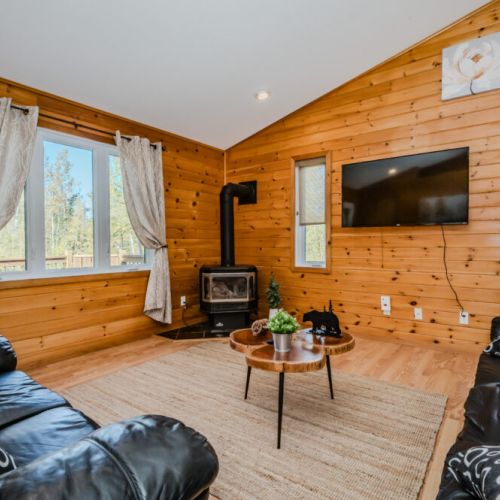 The open-concept living area featuring vaulted ceilings, a propane fireplace, and comfortable seating for cozy evenings.