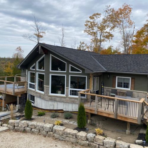 The striking front of Sunset Villa features large windows that flood the home with natural light and showcase beautiful forest views.