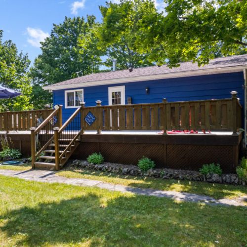 The charming blue cottage is surrounded by mature trees for added privacy.
