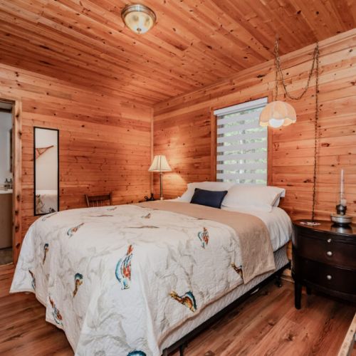 Warm wood-paneled bedroom , perfect for a tranquil lakeside holiday surrounded by nature and comfort.