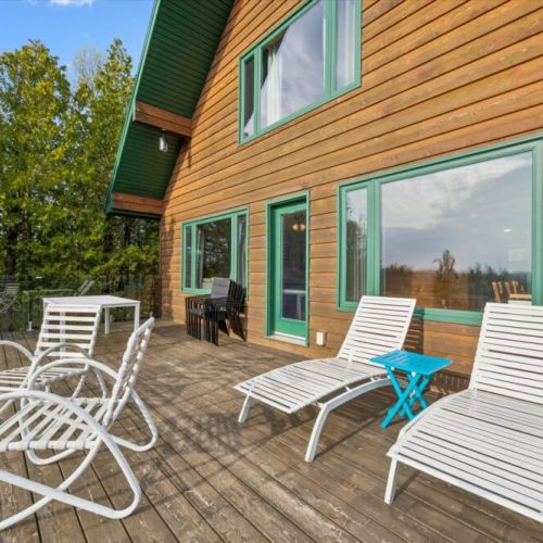 Relax in the sun on the spacious waterfront deck overlooking the trees and water.
