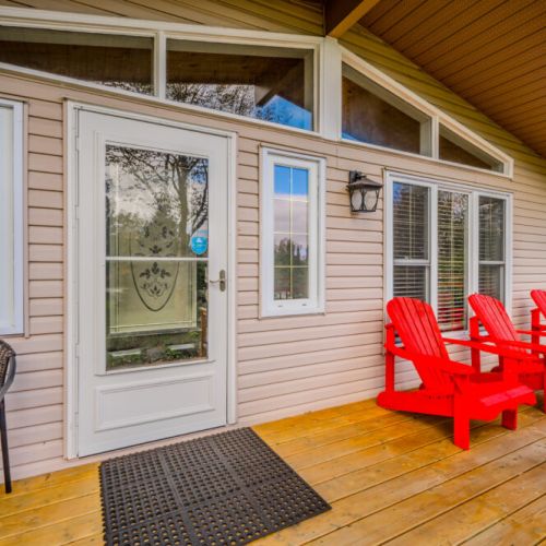 Enjoy your morning coffee or evening drink on the front deck, complete with bright red Adirondack chairs, perfect for soaking in the peaceful surroundings.