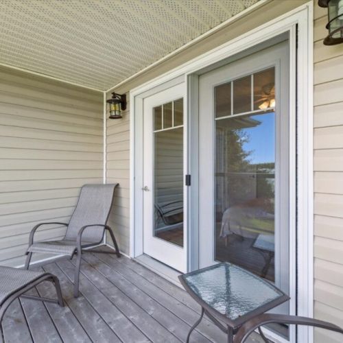 Covered balcony with comfortable lounge seating and a side table, offering a peaceful spot to relax and enjoy the fresh air just outside the bedroom.