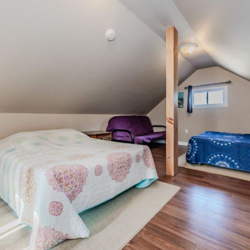 The loft area has multiple beds, ideal for accommodating extra guests or family members, with a cozy and open layout.