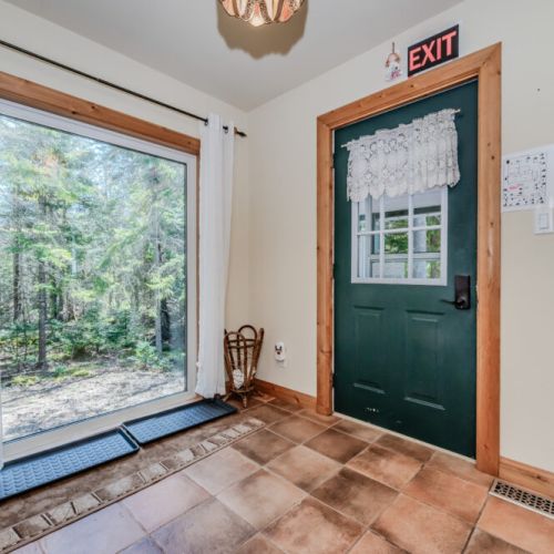 Bright entryway with large forest-facing window and direct access to trails—your gateway to nature starts here.