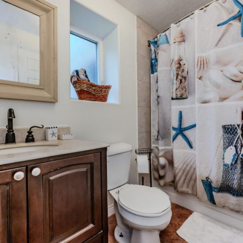The nautical-themed bathroom adds a fun touch to your stay, featuring beach-inspired decor and all the essentials for a comfortable experience.