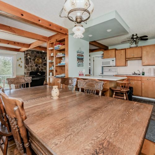 The dining area, flooded with natural light, offers a serene setting for meals. The rustic decor and comfortable seating make it an inviting space for family gatherings and dining.
