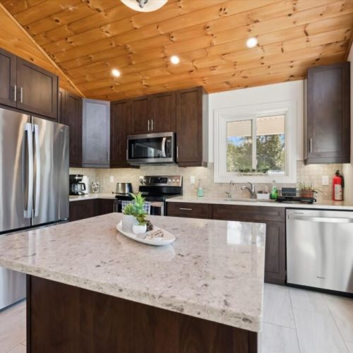 The fully equipped kitchen features modern appliances, ample counter space, and a central island for meal preparation.