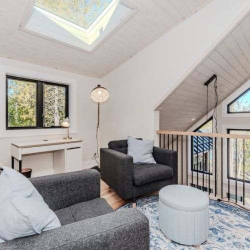 Bright and airy loft with a skylight and serene forest views, perfect for reading, remote work, or unwinding. This cozy nook in your vacation rental brings a blend of nature, comfort, and modern cabin charm.