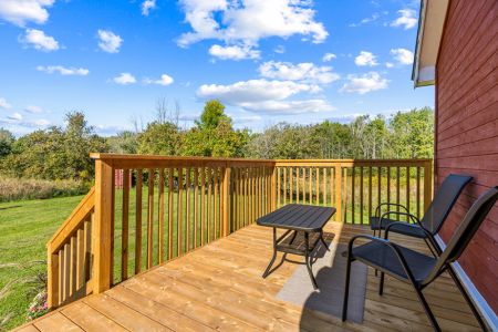 A sunny outdoor sitting area overlooking the lawn and surrounding Bruce Peninsula countryside.