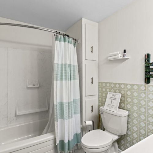 Clean, bright full bathroom with a tub and shower combination.