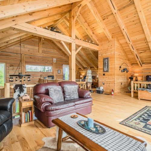 The expansive loft living area features comfortable seating, handcrafted furniture, and ample natural light, creating a welcoming and serene environment.