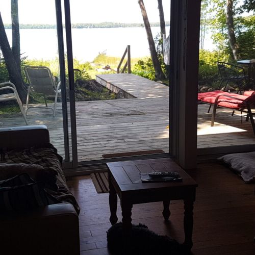 Charming Lakefront Cottage – Nestled among the trees, this classic waterfront retreat offers a peaceful and private escape. A beautiful wooden staircase leads to the spacious deck, where you can relax and enjoy the stunning lake views.